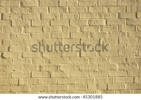 Texture of a brick wall covered in a thin layer of cement, with the form of the bricks still visible
