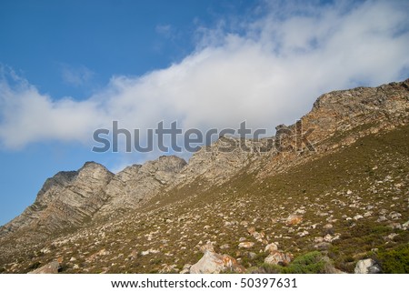 Rocky mountain with vivid blue skies and white clouds overhead