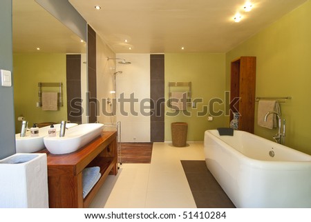 Modern bathroom with pastel coloured walls and white bath There's also a wood floored open shower Modern bathroom with pastel coloured walls and white bath There's also a wood floored open shower