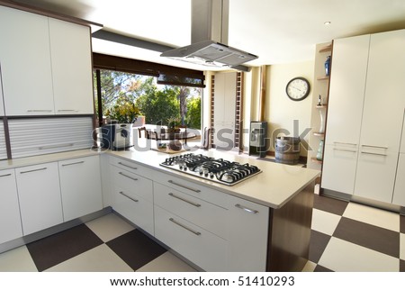 Modern kitchen with white and wood finished, and a silver hob overhead