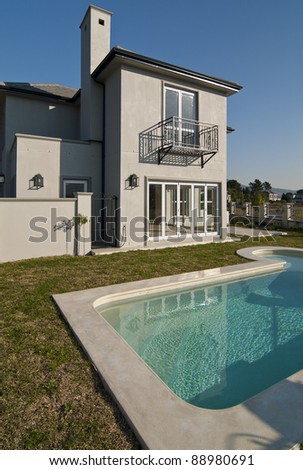Exterior of a luxury house with a swimming pool on a sunny day
