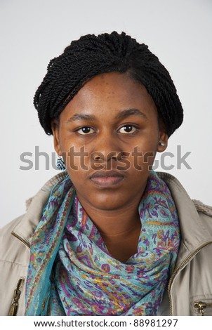 Head and shoulders shot of a young woman looking straight at the camera with a very neutral look