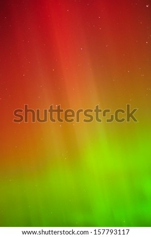 The aurora/northern lights shine in green, yellow and red over Lake Michigan. This is a close up of one of the curtains.