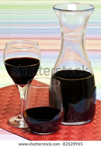 A carafe and glasses filled with red wine