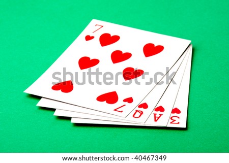 A set of four hearts playing cards that spell the word \