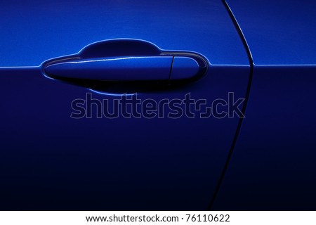 An abstract shot of a blue car door handle and panel line.