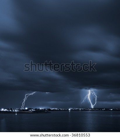 Signs - powerful lightning strikes over a lake in the city