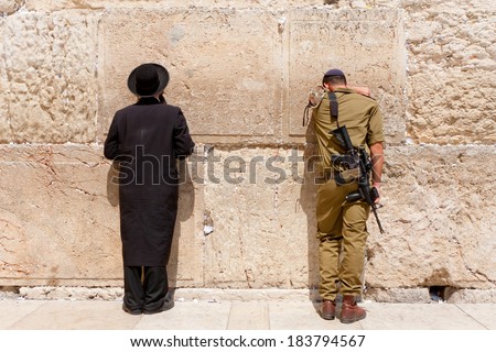 JERUSALEM - JULY 18, 2010: Soldier and orthodox jewish man pray at the western wall, Jerusalem
