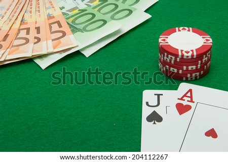 Blackjack hand with Euro notes and chips on green background