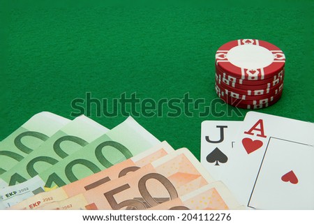 Blackjack hand with Euro notes and chips on green background