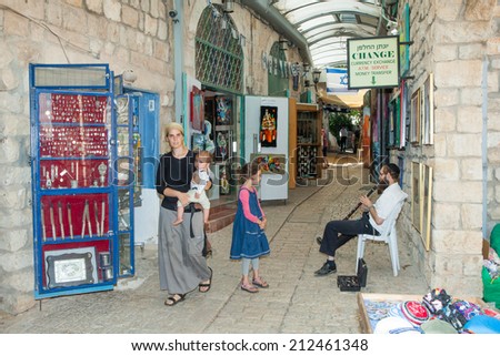 Safed, Israel - August 21, 2014: Tourists walk by shops and art galleries in Safed\'s old city alleys