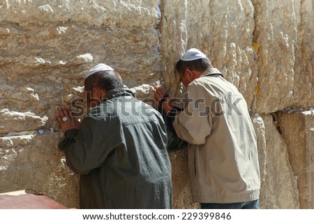 Jerusalem, Israel - November 9, 2014 : Two men  pray at the western wall. The western wall is an exposed section of ancient wall situated on the western flank of the Temple Mount.