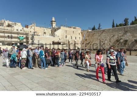 Jerusalem, Israel - November 9, 2014 : Group of Tourists at Jerusalem\'s wailing wall compound with blue sky and  the wailing wall in the background