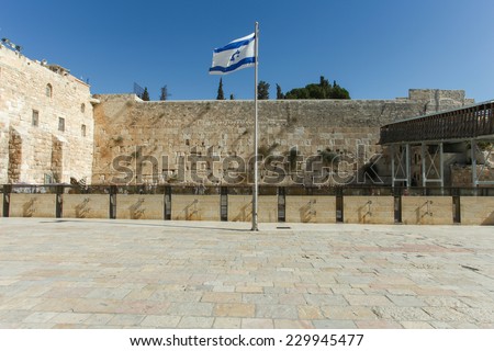 Jerusalem\'s wailing wall compound with blue sky, the Israeli flag and the wailing wall in the background