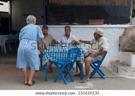 Santorini, Greece - October 2, 2010: diners sit in a traditional Greek restaurant during summertime in the city center of Santorini island.