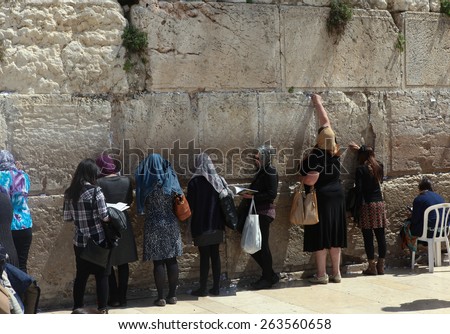 Jerusalem, Israel - March 24 2015 : Women and tourists pray at the western wall\'s women\'s section. The western wall is an exposed section of ancient wall placed on the western flank of the Temple.