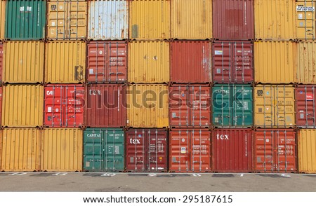 Haifa, Israel - July 10, 2015: Various brands and colors of shipping containers stacked in a holding platform waiting for loading.