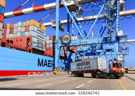 Haifa, Israel - October 15, 2015 : International Mega Container ship unloading containers on service trucks at Haifa's international port.