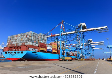 Haifa, Israel - October 15, 2015 : International Mega Container ship unloading containers on service trucks at Haifa\'s international port.