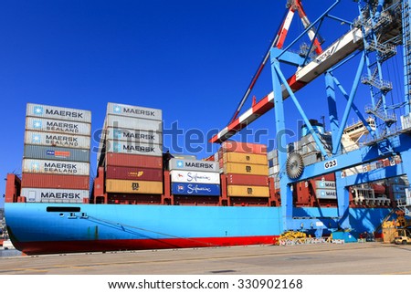 Haifa, Israel - October 15, 2015 : International Mega Container ship unloading containers on service trucks at Haifa\'s international port.