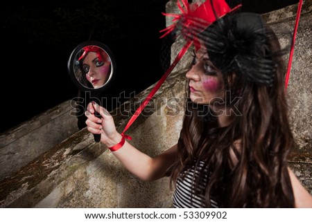Beautiful girl wearing red hat and striped skirt posing as a marionette (puppet on a string)