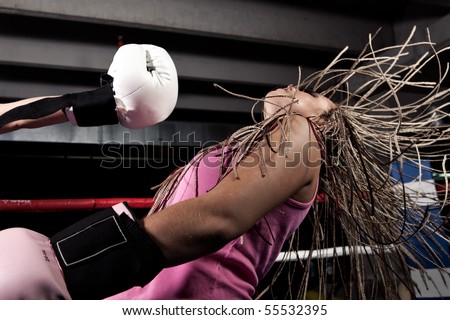 Blonde girl getting knocked out in a boxing ring