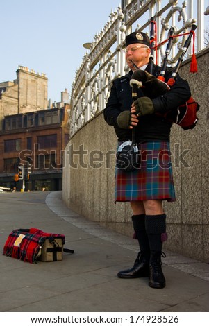 EDINBURGH, SCOTLAND, - MARCH 4: Unidentified Scottish Bagpiper playing music with bagpipe at Edinburgh on March 4, 2010. Edinburgh, the most popular tourist city destination in Scotland