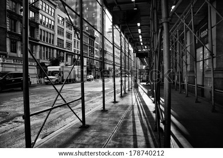 Shadows under some scaffolding on a street in New York, black and white shot