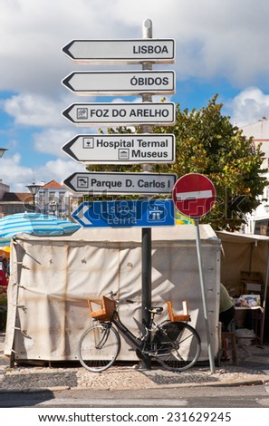 Directions pole with bike on the main square of Caldas da Ranha, Portugal