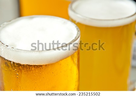 Three glasses of fresh and foamy beer just served