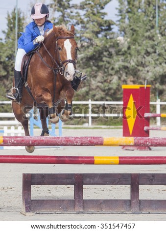BADAJOZ, SPAIN - Nov 22: Rider girl jumping with horse over obstacle at Poni Club Local Cup Qualifying competition on November 22, 2015 in Spain