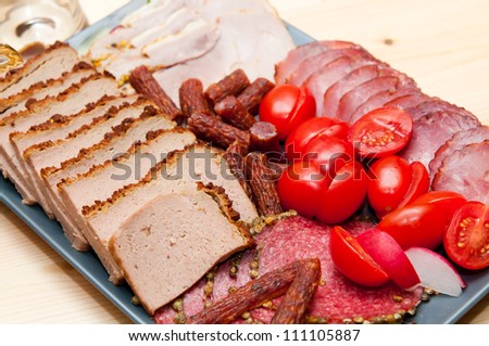 platter of cold cuts and sausages with ham and tomatoes