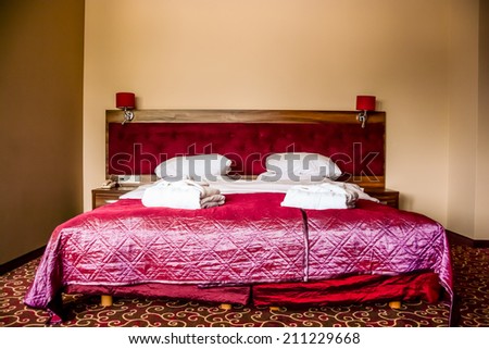 double bed in luxury hotel room with towels and bathrobe