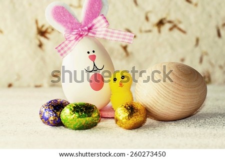 Easter still life with wooden and chocolate eggs, chicken and bunny