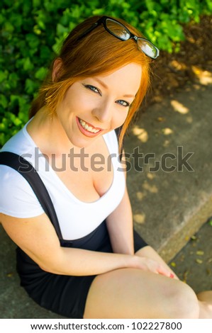 Portrait of Young Woman with Glasses and Suspenders Looking up at Camera
