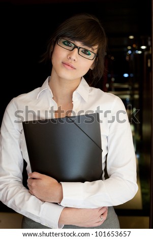 Young beautiful asian woman in business suit holding a folder.
