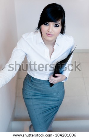 Sensual asian secretary holding a folder