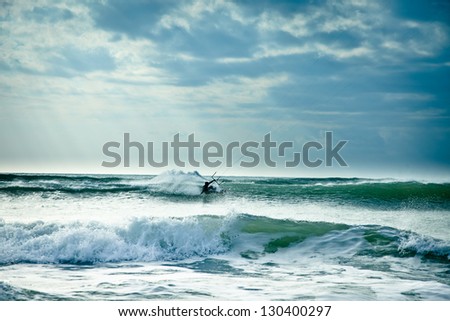 KITE BOARDING. Kite surfer in waves.