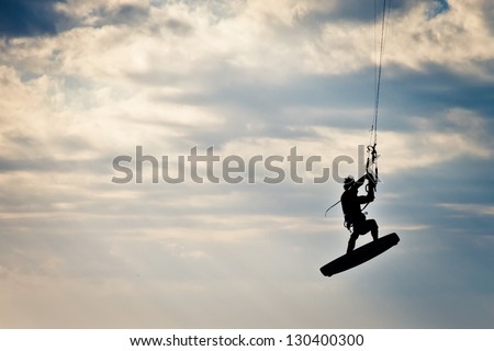 KITE BOARDING. Kite surfer flying up high.