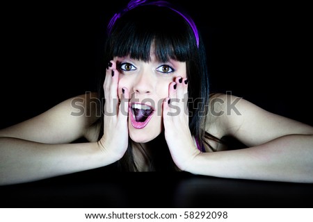 Pretty young woman looking surprised with a black background