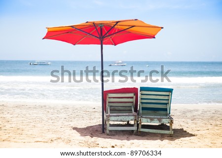 Deck chairs and shade in an empty beach.