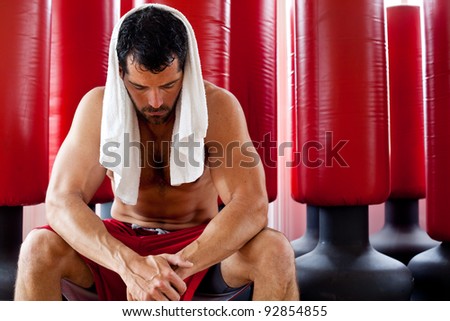 Attractive muscular man with a towel on his head sweating and looking tired. Fighter.