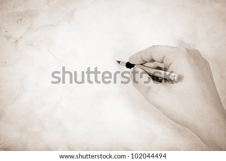 writing hand at old vintage paper parchment background