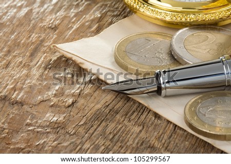 ink pen and watch on wooden background