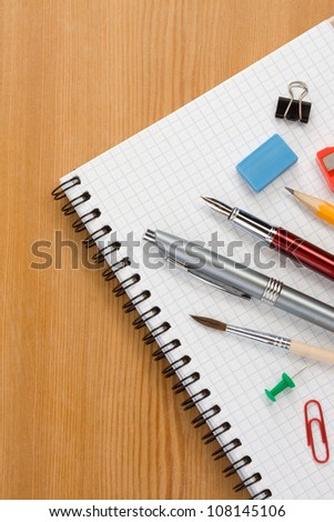 school supplies on checked paper notepad