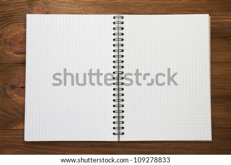 checked notepad  on wood background