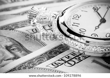 gold watch on dollar money banknotes