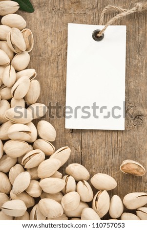 pistachios and tag paper label on wood background
