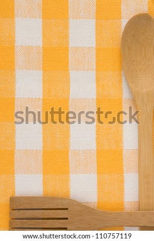 wood utensils at table napkins checked background