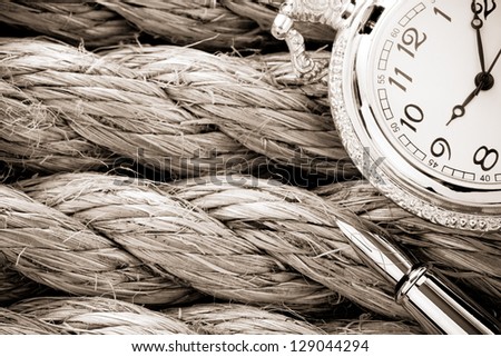 pocket watch with ink pen on ship ropes